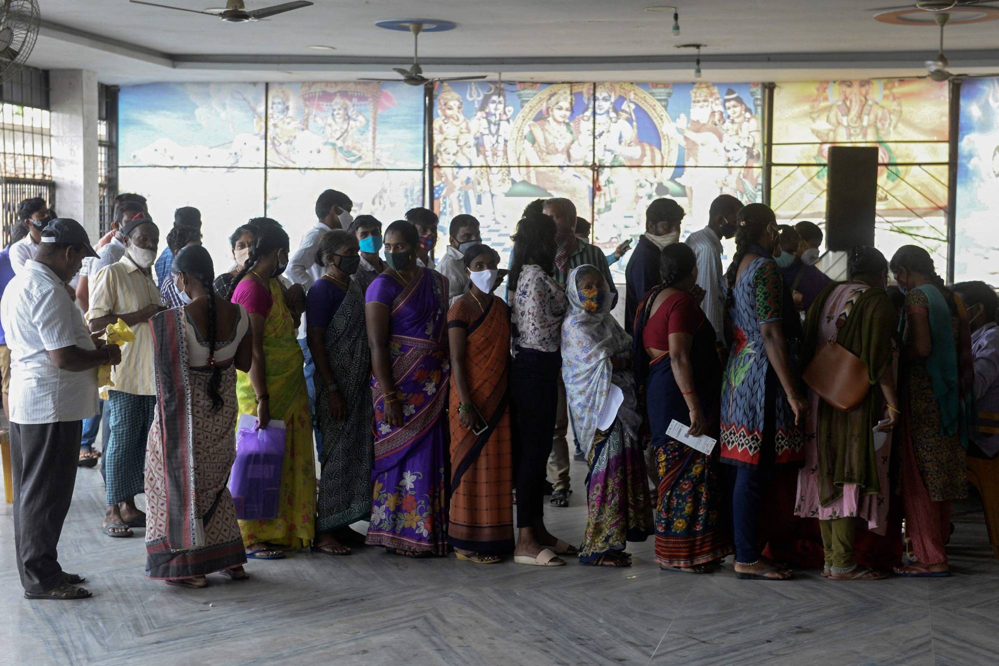 People line up to register for a dose of the Covishield COVID-19 vaccine at an Hindu temple on the outskirts of in Hyderabad on July 15. | AFP-Jiji