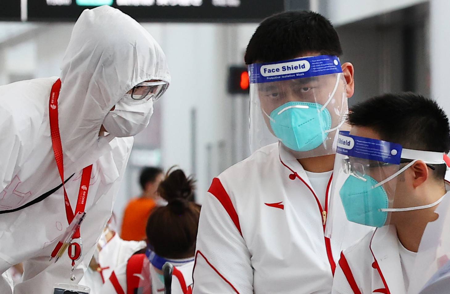 Chinese Basketball Association President Yao Ming (center) stands with staffers during the quarantine process after arriving at Narita Airport in Chiba Prefecture on July 19 ahead of the Tokyo Games. | REUTERS