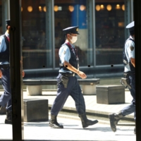 Police officers observe social distancing ahead of the Tokyo 2020 Olympic Games, postponed to 2021 due to the COVID-19 pandemic. | REUTERS