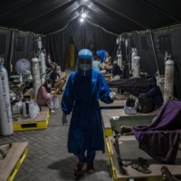 COVID-19 patients are treated outside a hospital in Yogyakarta, Indonesia, on July 16. | BLOOMBERG 