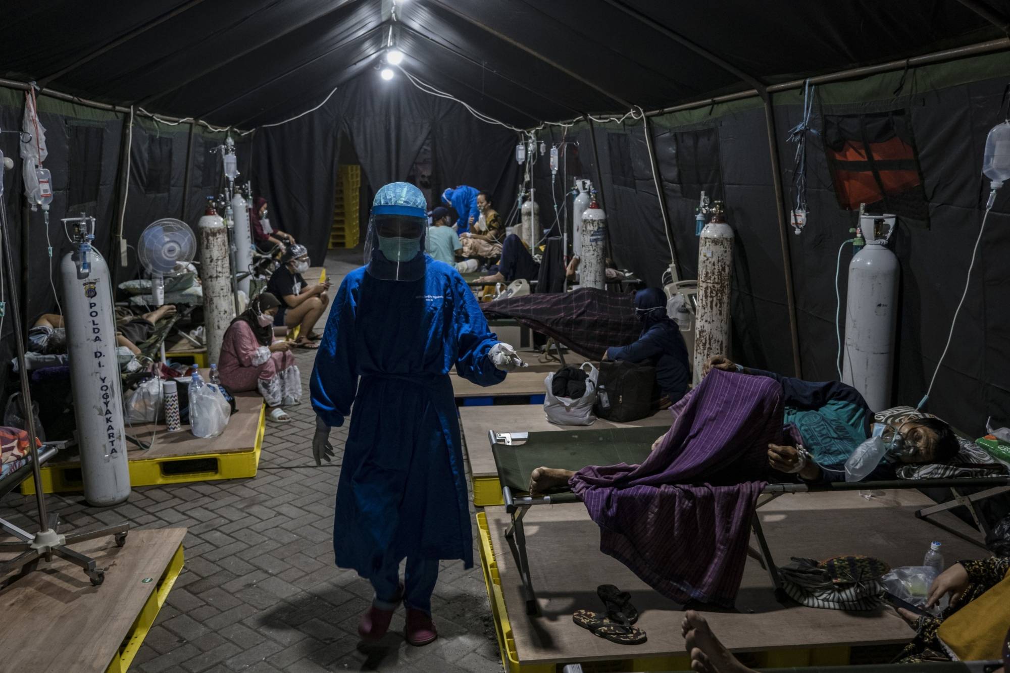 COVID-19 patients are treated outside a hospital in Yogyakarta, Indonesia, on July 16. | BLOOMBERG 