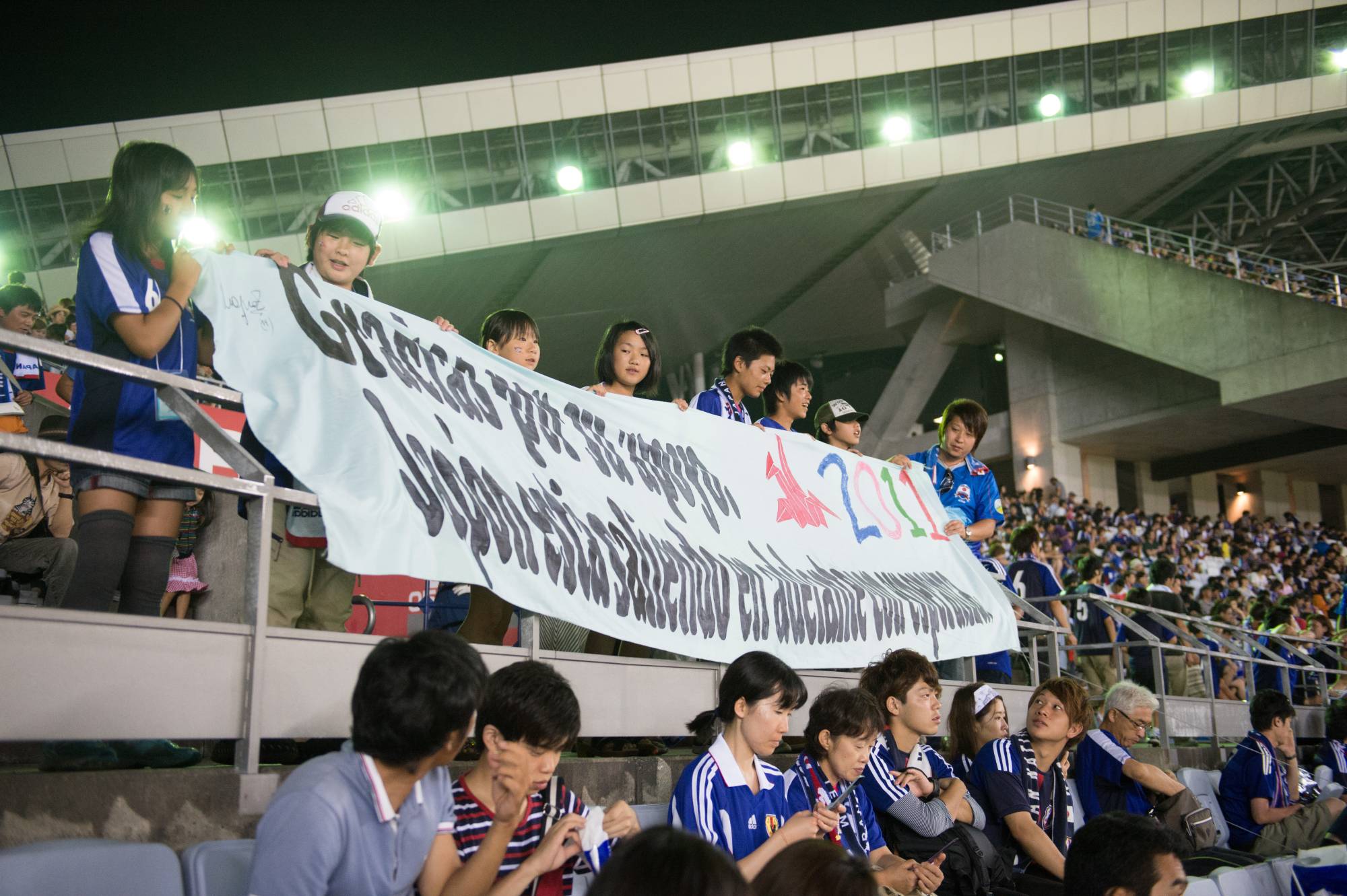 Tohoku-area schoolchildren hold up a Spanish-language banner at an international friendly between Japan and Uruguay on Aug. 14, 2013, in Rifu, Miyagi Prefecture. | Dan Orlowitz