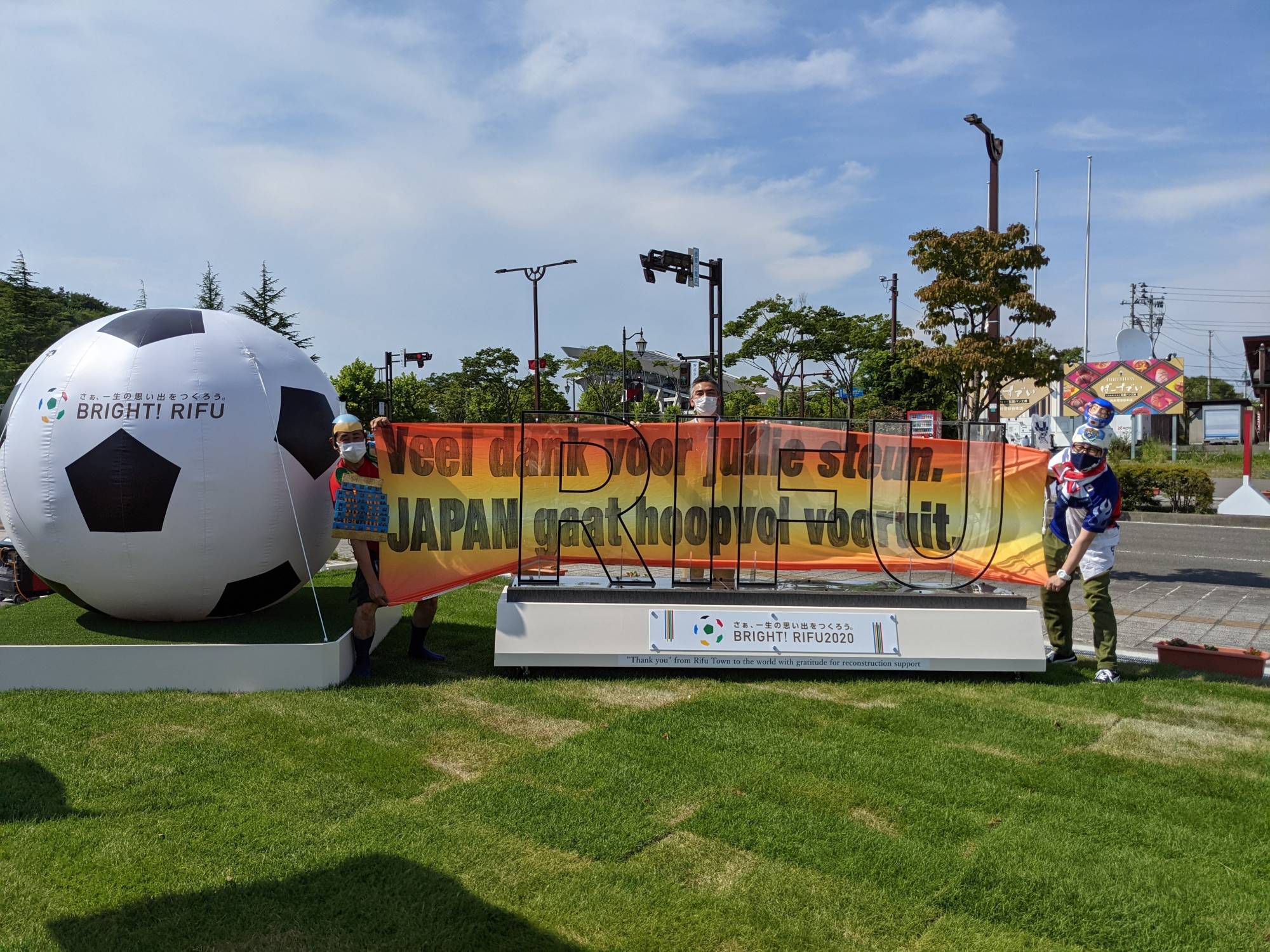 Hirokazu Tsunoda (left) holds up a Dutch-language banner along with Rifu mayor Yutaka Kumagai on Wednesday outside Miyagi Stadium. | Courtesy of Hirokazu Tsunoda 