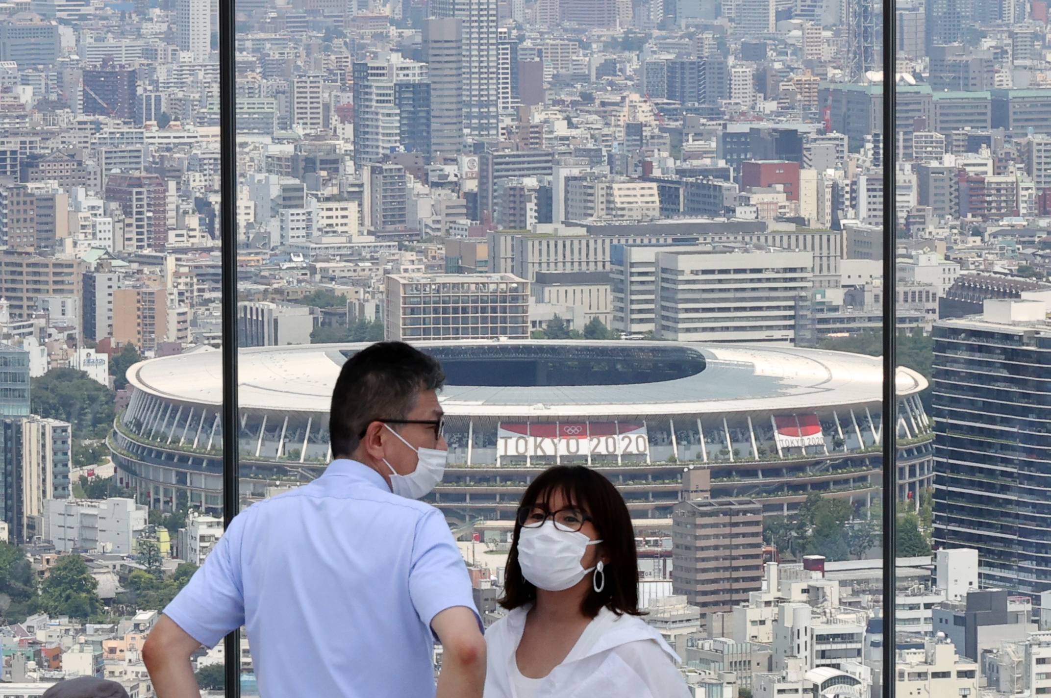 Visitors at an observation deck overlooking the National Stadium in Tokyo on Friday | REUTERS