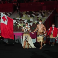 Flag bearers Malia Paseka and Pita Taufatofua lead the Olympic team from Tonga into the Olympic Stadium  | DOUG MILLS / THE NEW YORK TIMES