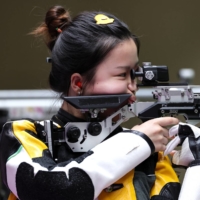 Yang Qian of China in action won the first gold medal of the Tokyo Olympics in the women\'s 10-meter Air Rifle competition on Saturday. | REUTERS