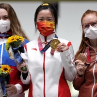 Gold medalist Yang Qian of China celebrates on the podium with silver medalist, Anastasiia Galashina of the Russian Olympic Committee, and bronze medalist, Nina Christen of Switzerland. | REUTERS