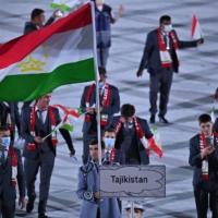Athletes from the Tajikistan Olympic team, some maskless, take part in the Tokyo Games\' opening ceremony on Friday.  | AFP-JIJI
