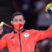 Naohisa Takato celebrates after winning the gold medal in the men\'s judo under-60 kg competition at the Tokyo Olympics at Nippon Budokan on Saturday. The medal was Japan\'s first gold of the Tokyo Games. | REUTERS