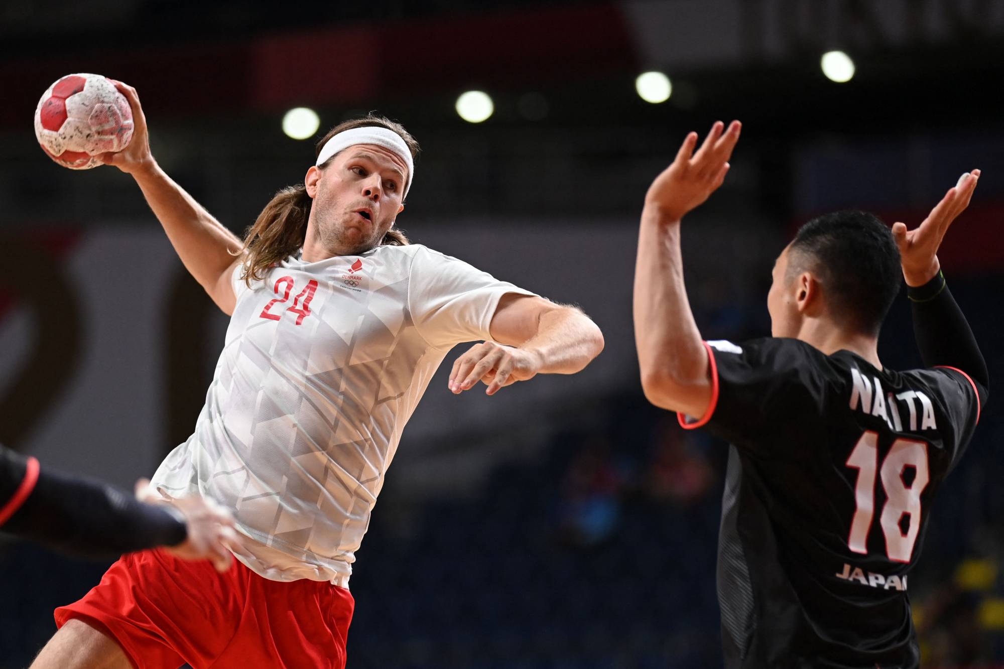 Denmark's left back Mikkel Hansen (left) jumps to shoot during the men's preliminary round group B handball match between Denmark and Japan. | AFP-JIJI