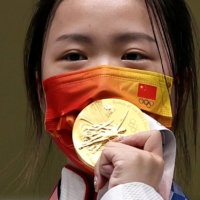 Gold medalist Yang Qian of China celebrates on the podium. | REUTERS