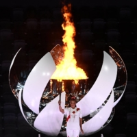 Naomi Osaka holds the Olympic Torch after lighting the flame of hope in the Olympic Cauldron during the opening ceremony of the Tokyo Games, at the National Stadium on Friday. | AFP-JIJI