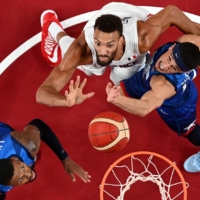 Rudy Gobert of France in action at the rim with Damian Lillard and Devin Booker of the United States at Saitama Super Arena on Sunday | REUTERS 
