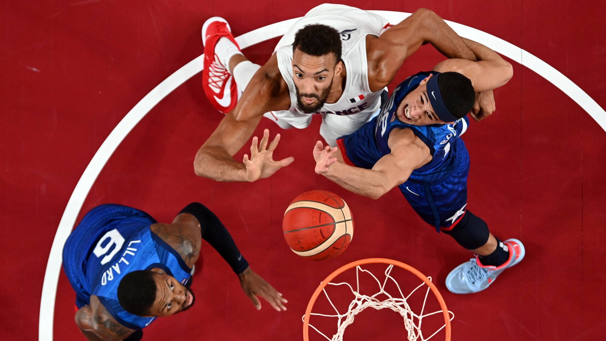 Rudy Gobert of France in action at the rim with Damian Lillard and Devin Booker of the United States at Saitama Super Arena on Sunday | REUTERS 