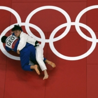 Japan\'s Hifumi Abe (white) competes with Georgia\'s Vazha Margvelashvili during their Olympic judo men\'s 66 kg final bout at Nippon Budokan in Tokyo on Sunday. | AFP-JIJI