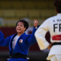 Uta Abe celebrates after winning the women\'s under-52 kg gold-medal bout against France\'s Amandine Buchard on Sunday in Tokyo. | AFP-JIJI