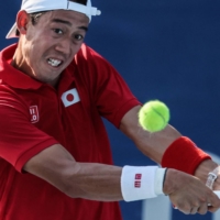 Japan\'s Kei Nishikori returns a shot to Portugal\'s Pedro Sousa and Portugal\'s Joao Sousa during their Tokyo 2020 Olympic Games men\'s doubles first round tennis match on Sunday. | AFP-JIJI
