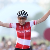 Austria\'s Anna Kiesenhofer celebrates winning gold in the women\'s road race. | POOL / VIA REUTERS