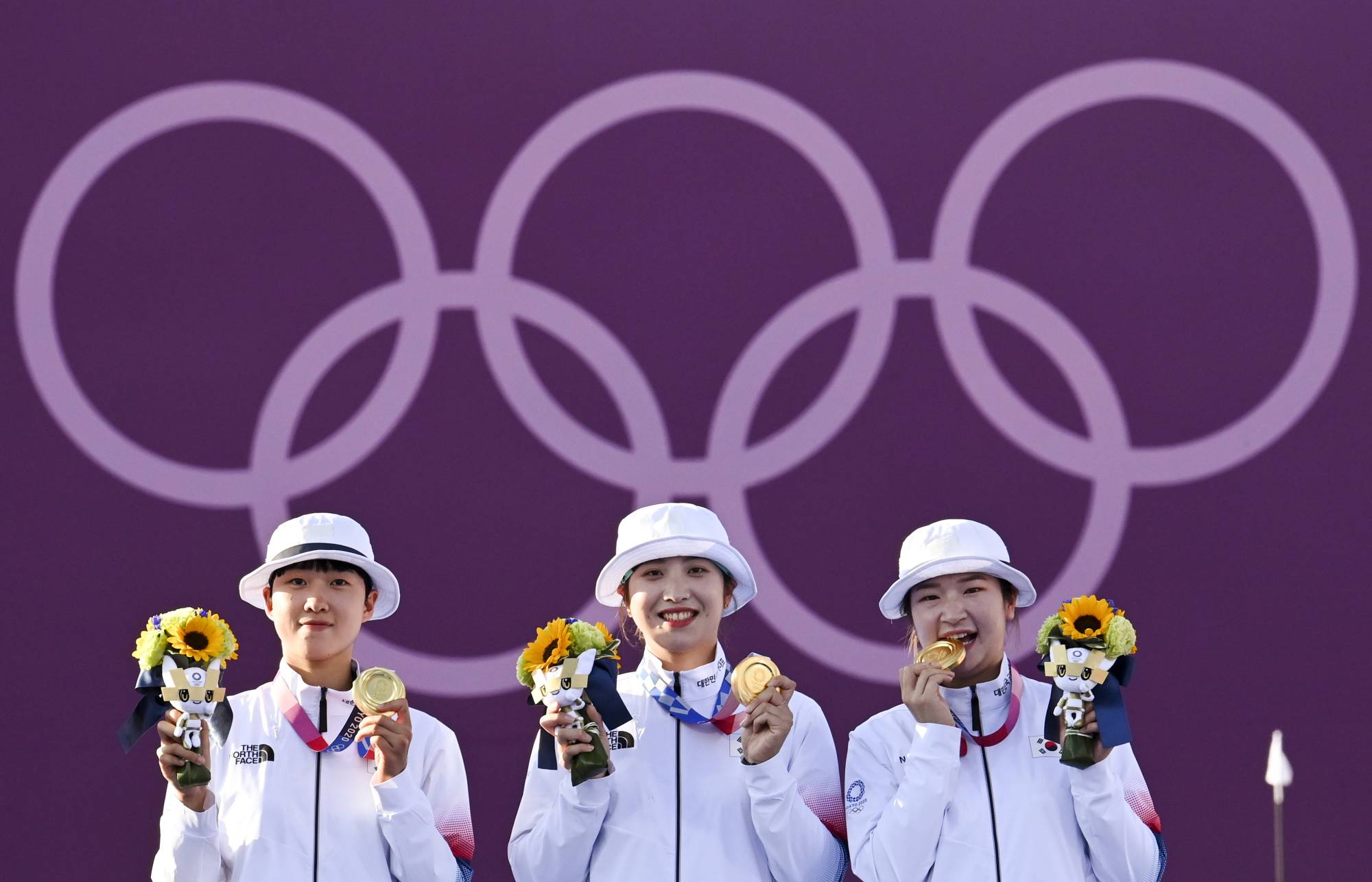 South Korean gold medalists An San, Jang Minhee and Kang Chae Young of South Korea celebrate on the podium. | REUTERS