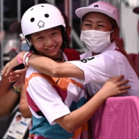 Japan\'s Momiji Nishiya celebrates with her coach after winning the skateboarding women\'s street final in Tokyo on Monday.  | AFP-JIJI