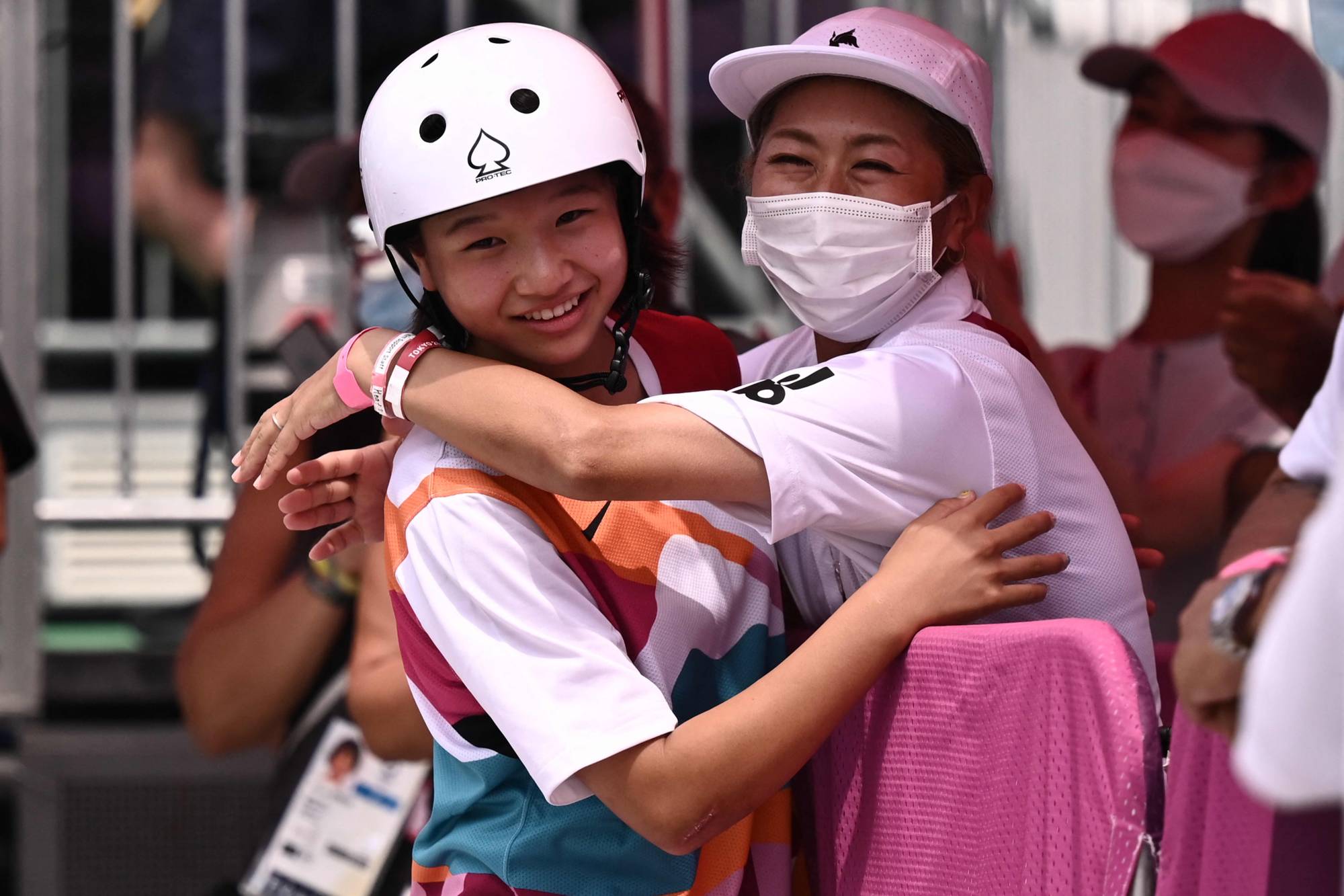 Japan's Momiji Nishiya celebrates with her coach after winning the skateboarding women's street final in Tokyo on Monday. | AFP-JIJI
