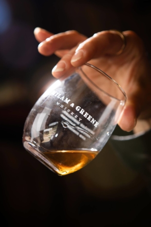 Heather Greene, one of the founders, holds a glass at the Milam & Greene distillery in Blanco, Texas, in May 2021. In just the few years since its founding, Milam & Greene has become one of the most highly regarded distilleries in Texas. | JESSICA ATTIE / THE NEW YORK TIMES