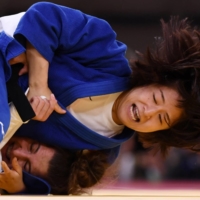 Tsukasa Yoshida of Japan (top) battles Eteri Liparteliani of Georgia on Monday in their bronze-medal bout.  | REUTERS