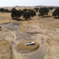 A lone boat sits perched on a mound near Hensley Lake as soaring temperatures and drought continue to affect livestock and water supplies in Madera, California, on July 14. | REUTERS