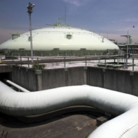 An in-ground liquefied natural gas tank (left), and an above ground storage type LNG tank stand at Tokyo Gas Co.\'s Negishi LNG terminal in Yokohama. | BLOOMBERG