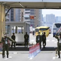 Security personnel stand at a gate for the athletes\' village for the Tokyo Games. | KYODO