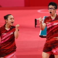 Japan\'s Mima Ito and Jun Mizutani pump their fists during the mixed doubles Olympic gold-medal match on Monday in Tokyo. | REUTERS