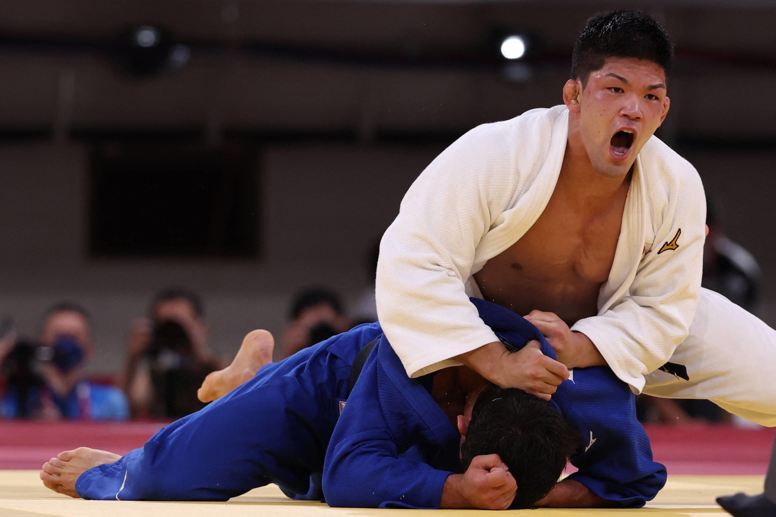 Japan's Shohei Ono (white) and Georgia's Lasha Shavdatuashvili compete in the judo men's -73 kg final bout during the Tokyo 2020 Olympic Games at the Nippon Budokan in Tokyo on Monday. | AFP-JIJI