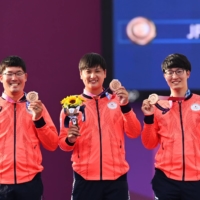 Takaharu Furukawa, Yuki Kawata and Hiroki Muto celebrate their bronze medals on the podium on Monday.  | REUTERS