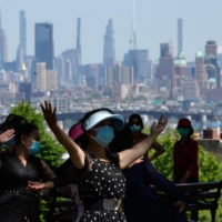 Women dance in a park in New York in May.  | AFP-JIJI