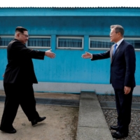 South Korean President Moon Jae-in and North Korean leader Kim Jong Un shake hands at the truce village of Panmunjom inside the Demilitarized Zone separating the two Koreas in April 2018.  | KOREA SUMMIT PRESS POOL / VIA REUTERS