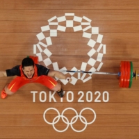 China\'s Shi Zhiyong celebrates during the men\'s 73-kg weightlifting | POOL VIA REUTERS