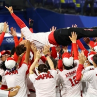 Japan\'s softball team celebrates with manager Reika Utsugi after winning gold in softball on Tuesday.  | REUTERS