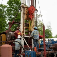 Workers operate a drill rig at a gas well plugging site in Roan County, West Virginia. | REUTERS 