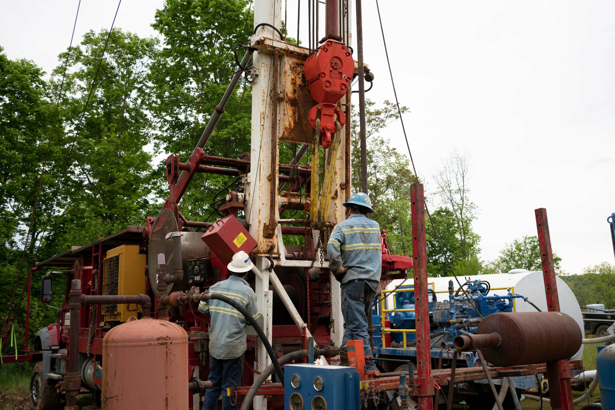 Workers operate a drill rig at a gas well plugging site in Roan County, West Virginia. | Reuters 