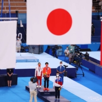 (From left) Silver medalist Ruoteng Xiao of Team China, gold medalist Daiki Hashimoto of Team Japan and bronze medalist Nikita Nagornyy of Team ROC stand on the podium during the medal ceremony following the Men\'s All-Around Final on day five of the Olympic Games at Ariake Gymnastics Center on Wednesday. | GETTY IMAGES / VIA BLOOMBERG