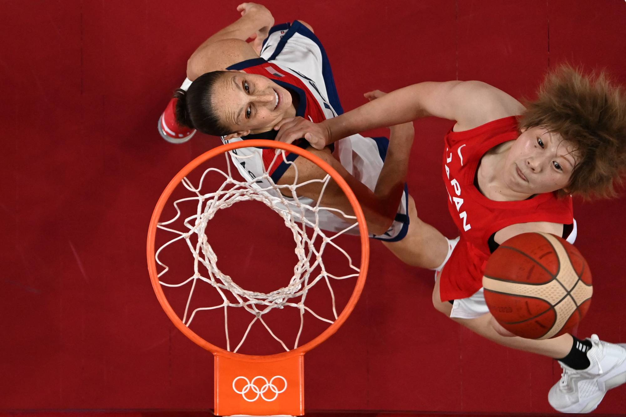 Diana Taurasi of the U.S. (left) and Japan's Maki Takada jump for the ball in their group match at Saitama Super Arena on Friday. | AFP-JIJI