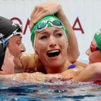 Swimmers in the women\'s 200-meter breaststroke congratulate South Africa\'s Tatjana Schoenmaker for setting a new world record. | REUTERS