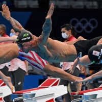 Swimmers dive in at the start of a heat for the men\'s 50-meter freestyle swimming event | AFP-JIJI