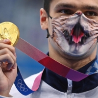 Russia\'s Evgeny Rylov, wearing a decorated face mask, displays his gold medal for the men\'s 200-meter backstroke swimming  | AFP-JIJI