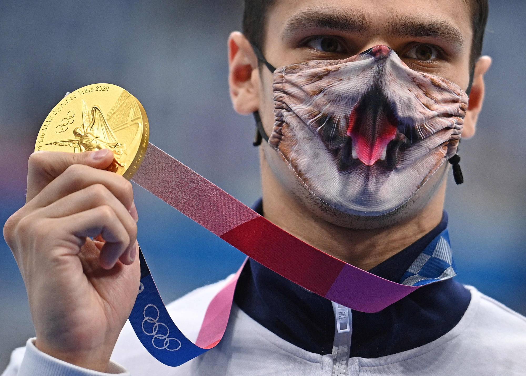 Russia's Evgeny Rylov, wearing a decorated face mask, displays his gold medal for the men's 200-meter backstroke swimming  | AFP-JIJI