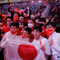Fencers Koki Kano, Kazuyasu Minobe, Masaru Yamada and Satoru Uyama celebrate with team members after winning gold in the men\'s epee team event on Friday. | REUTERS