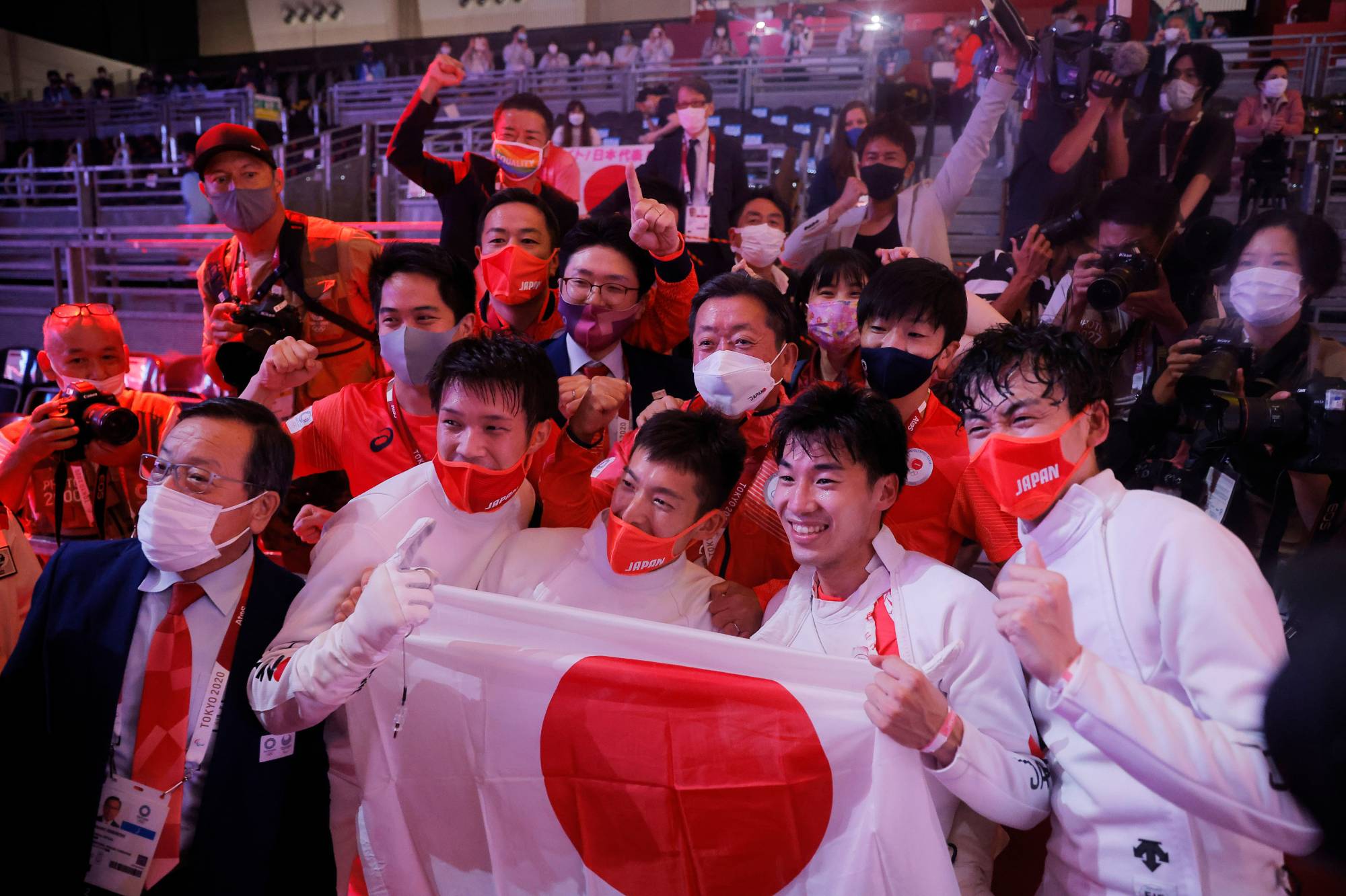 Fencers Koki Kano, Kazuyasu Minobe, Masaru Yamada and Satoru Uyama celebrate with team members after winning gold in the men's epee team event on Friday. | REUTERS