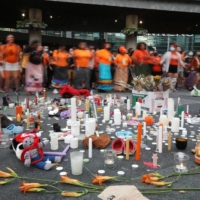 People participate in a round dance in front of candles and items placed on the ground in honor of the hundreds of remains of children discovered at former indigenous residential schools, on Thursday in Toronto.  | REUTERS