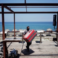 A worker removes furniture from a restaurant terrace as Storm Elsa approaches the island, in Havana on Saturday.  | REUTERS 