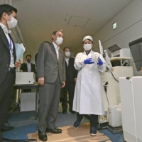 Prime Minister Yoshihide Suga visits Haneda Airport in Tokyo on June 28 to see how antigen tests are conducted. | POOL / VIA KYODO